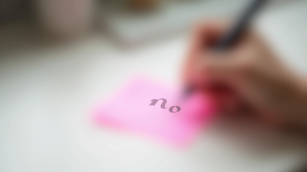 Mão escrevendo 'não' numa nota adesiva cor de rosa, mesa de trabalho minimalista com papéis